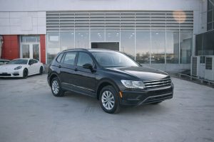 Svart SUV parkerad framför en bilhall vid ett företagsköp.